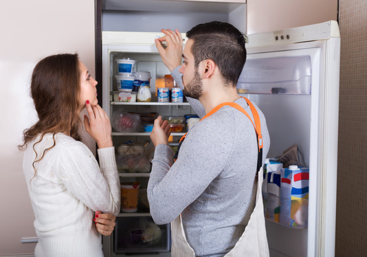 Housewife showing broken refrigerator